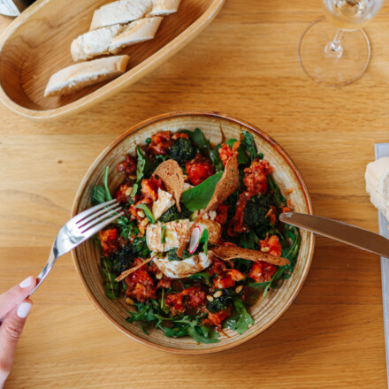 Eine Person genießt einen frischen Salat mit Brot im Wirtshaus "Zum Treffner".