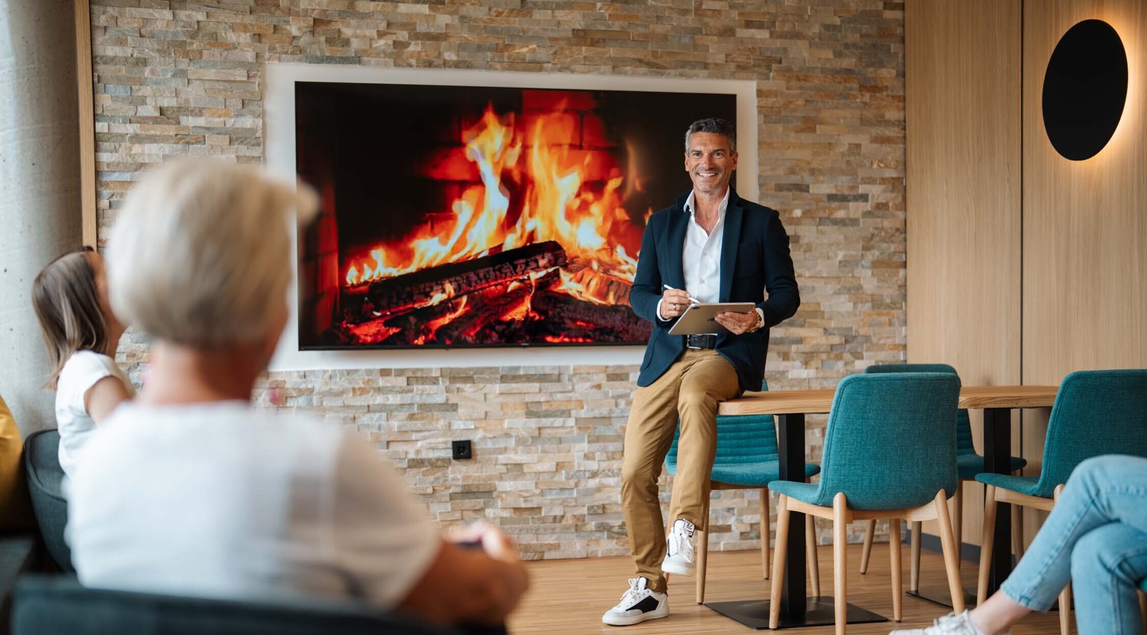 Seminare im Hotel eduCARE: ein Mann trägt vor Publikum etwas vor, während drei Frauen zuhöhren.
