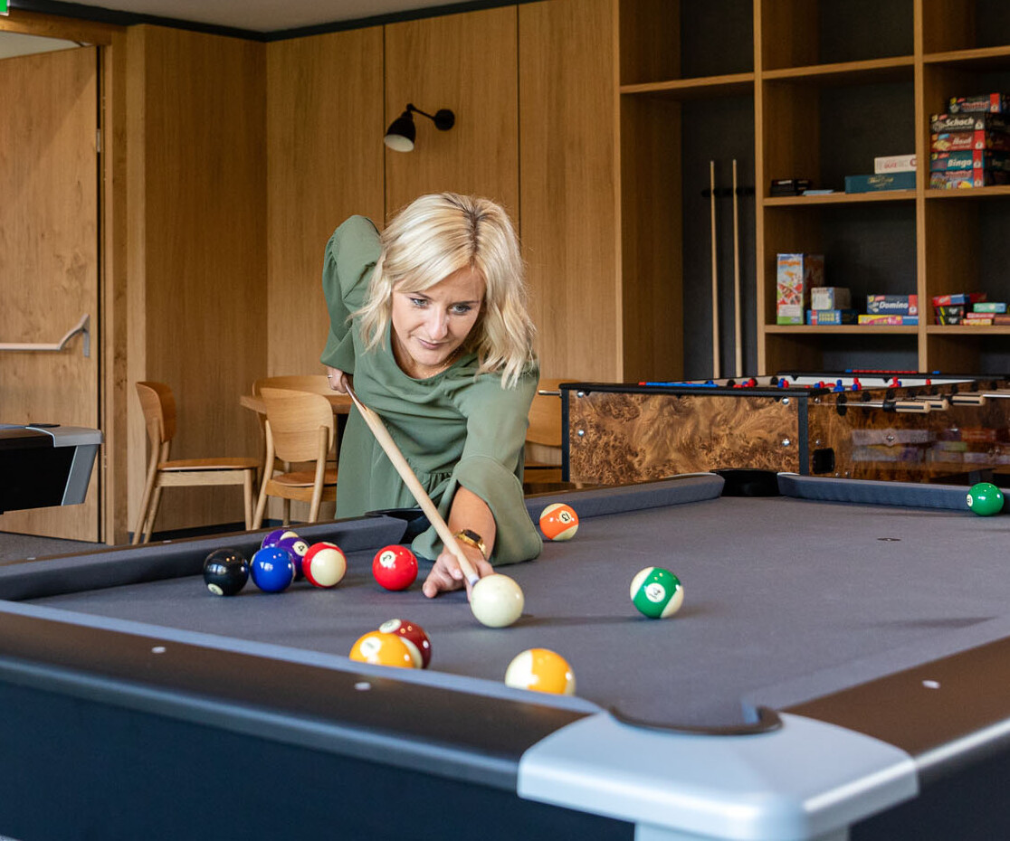 Eine Frau spielt Billiard im Hotel eduCARE