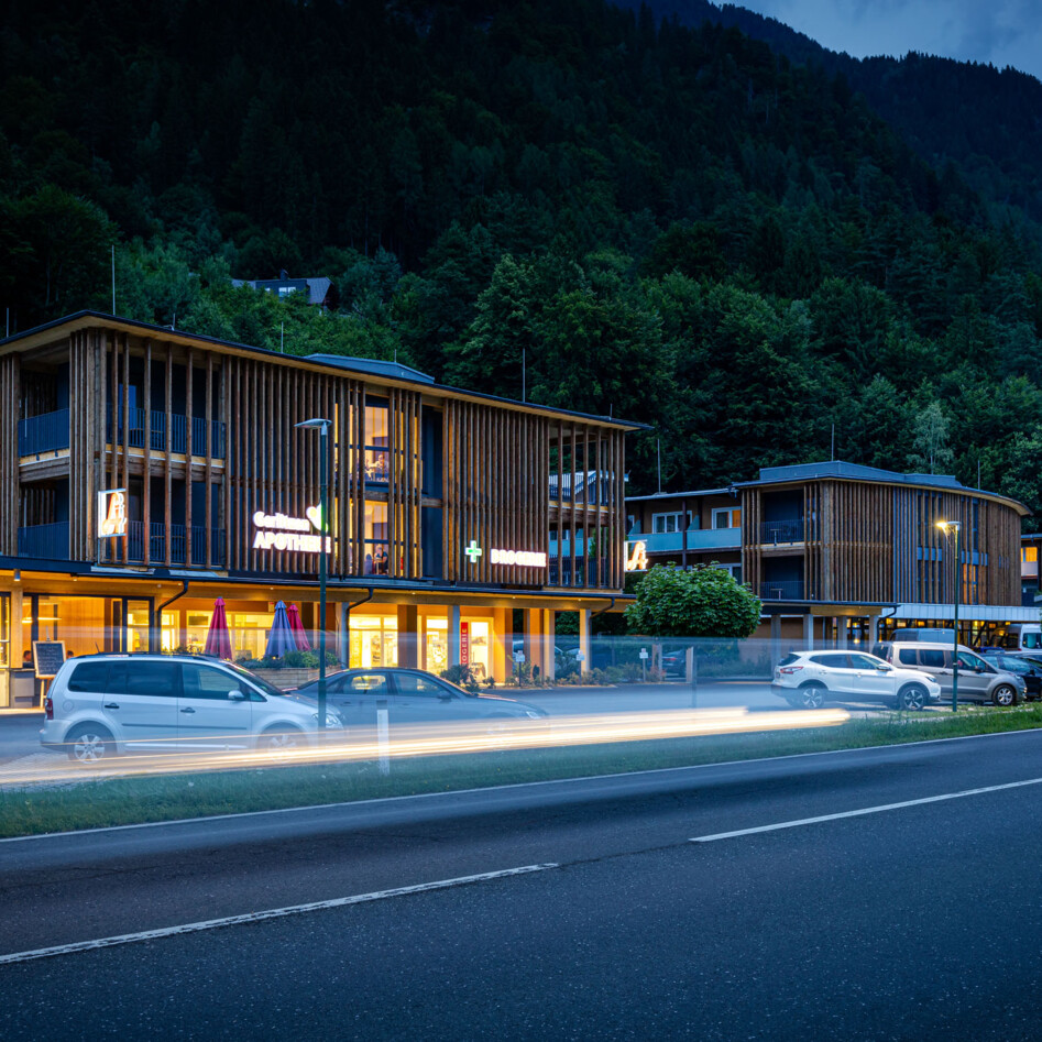 Das Hotel eduCARE bei Nacht mit Außenbeleuchtung. Vor den Gebäuden parken Autos. 